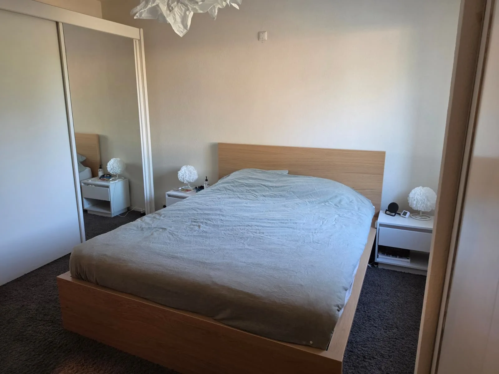 Slaapkamer met een bed en nachtkastjes in een appartement.