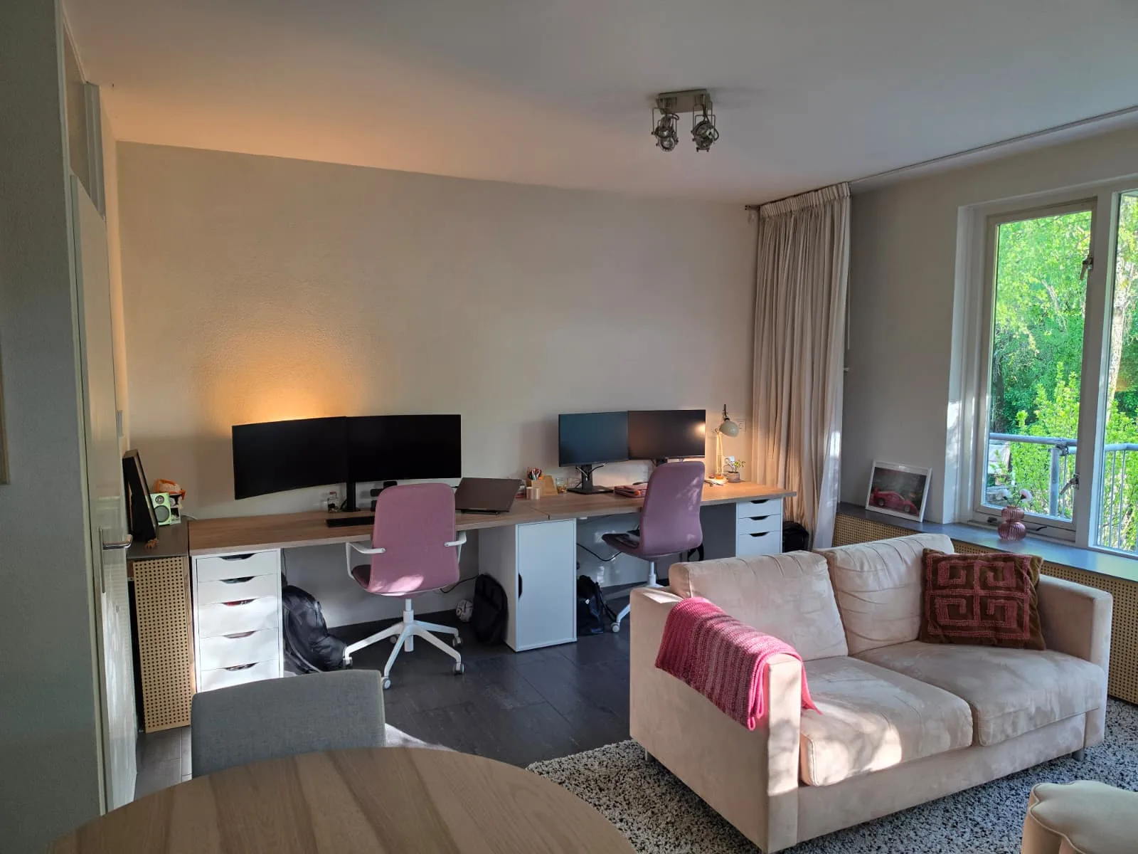 Moderne woonkamer met bureau en zithoek in appartement.