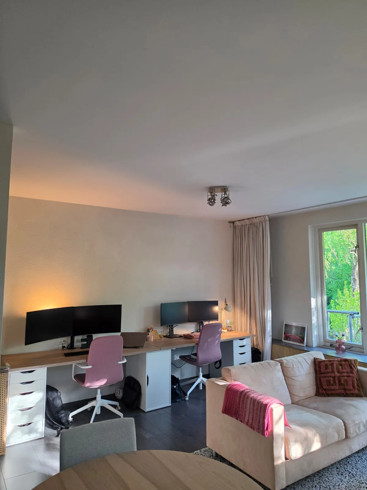 Moderne woonkamer met bureau en zithoek in appartement.