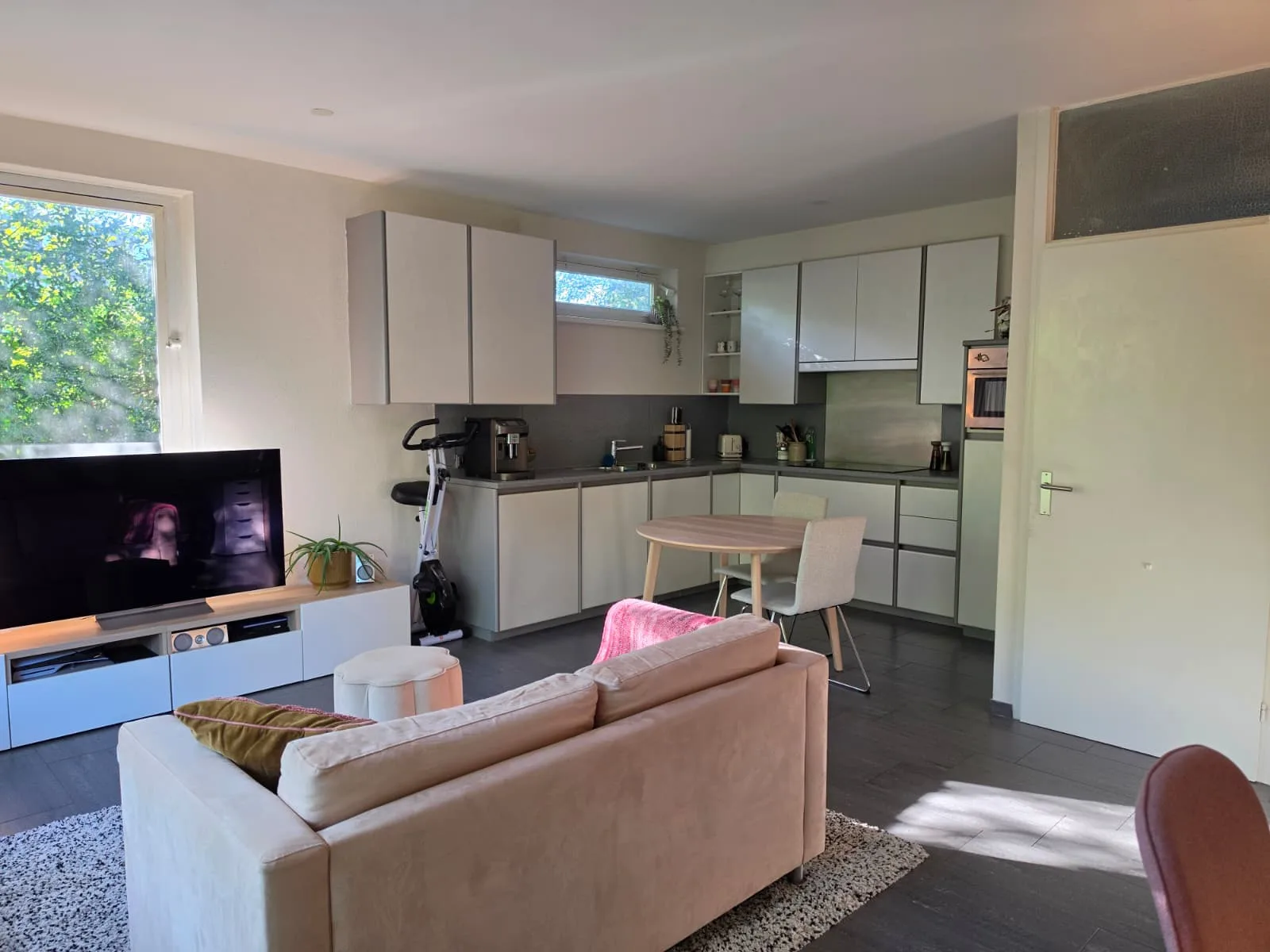 Moderne keuken met zithoek en tv in appartement.